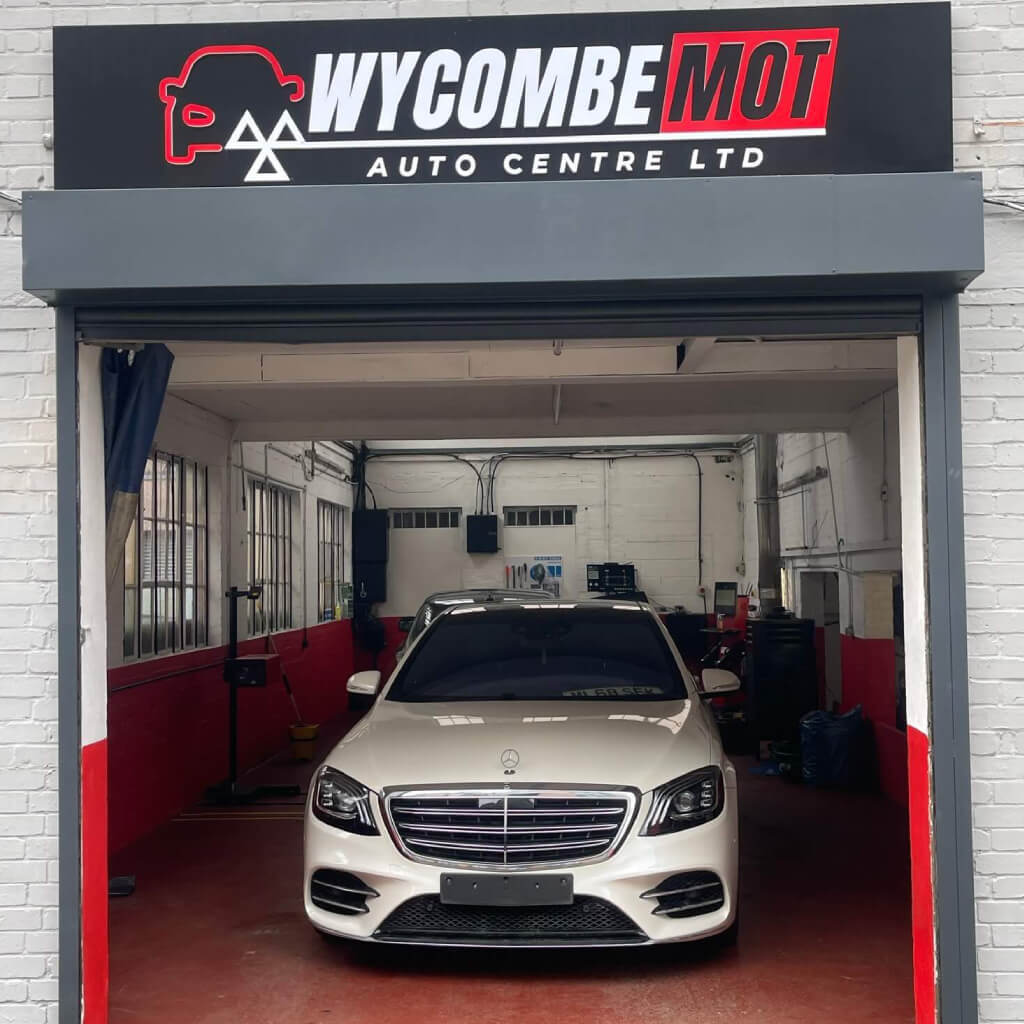 A Yellow car on a ramp inside the workshop