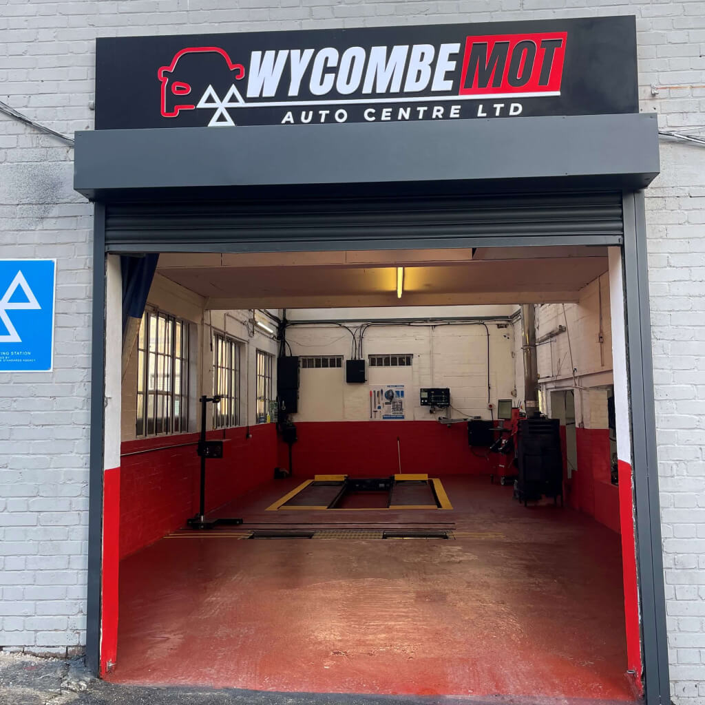 A Yellow car on a ramp inside the workshop